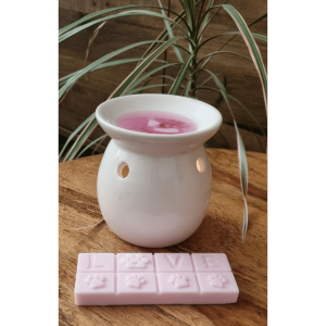 a wax melter with a pink wax melt bar with paws and love on it