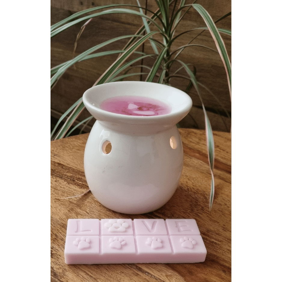 a wax melter with a pink wax melt bar with paws and love on it