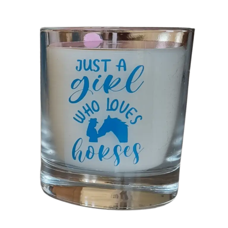 scented candle in glass container with just a girl who loves horses slogan and silhoette of girl and horse head allin blue